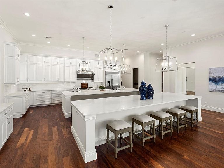 Completed white custom kitchen with walnut flooring and multiple work zones