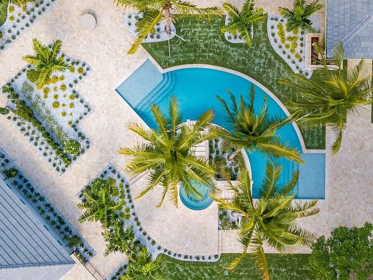 Completed resort-style pool surrounded by palm trees and tropical landscaping